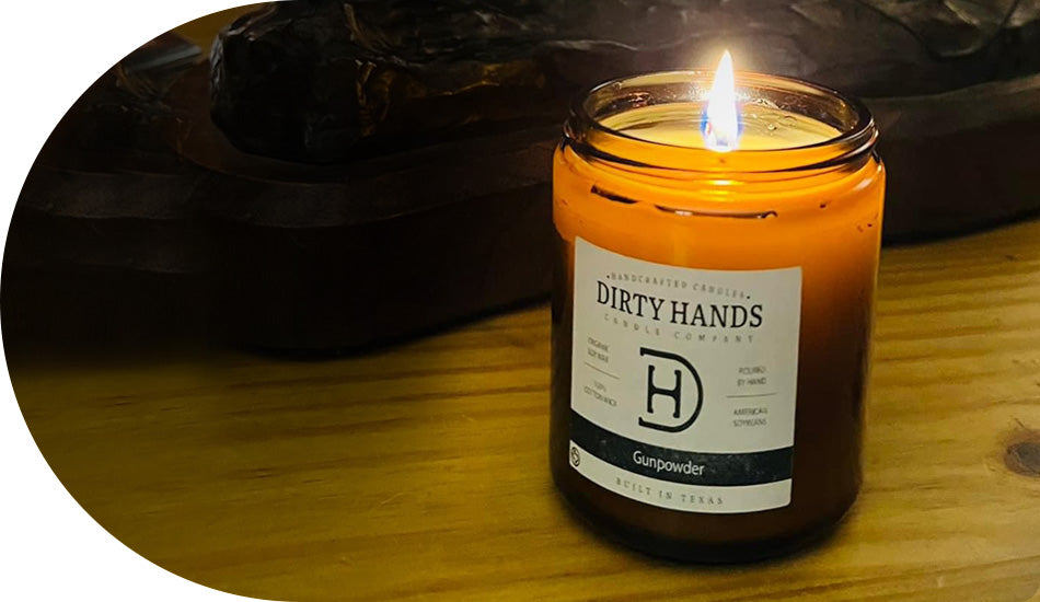 A Gunpowder Candle rests on a table beside a wooden bowl, creating a cozy and rustic atmosphere.