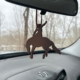 Leather cowboy on horse air freshener hanging from rearview mirror in a car, this link will open in a new tab.