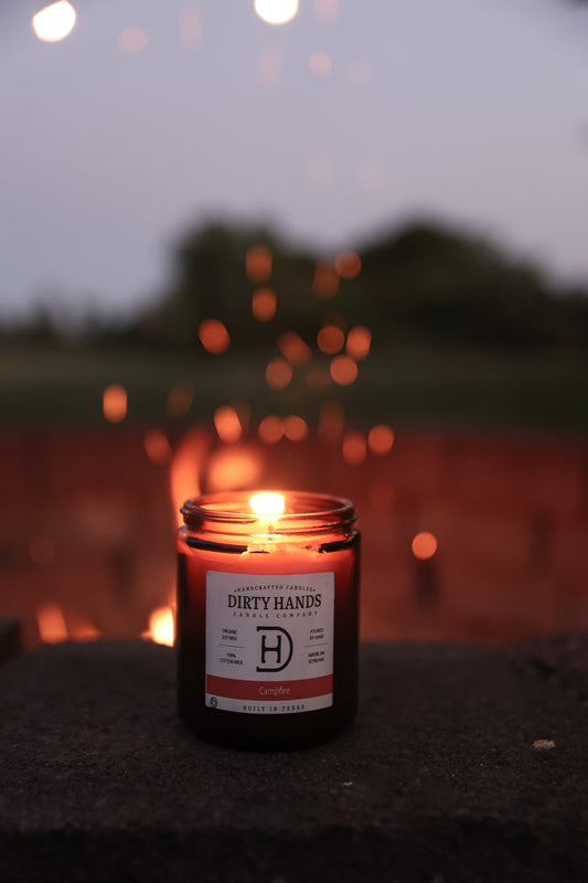 Campfire Candle Burning in front of a Camp Fire